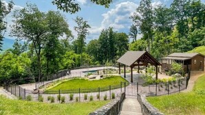 Un parque con un pabellón, un muro de piedra y un edificio de madera.