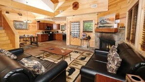 L’intérieur d’une cabane en rondins comprend un salon, une cuisine et une cheminée.