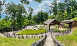 A park with a gazebo, a stone wall, and a wooden building. - Black Bear Getaway (Gatlinburg)