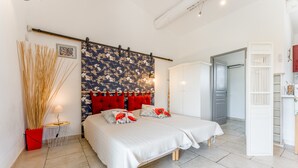 Ein Schlafzimmer mit Bett, Kleiderschrank und einer Badezimmertür.