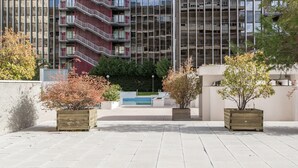 A modern building with multiple balconies and a pool in the background. - La Castellana - Plaza Catilla III (Madrid)