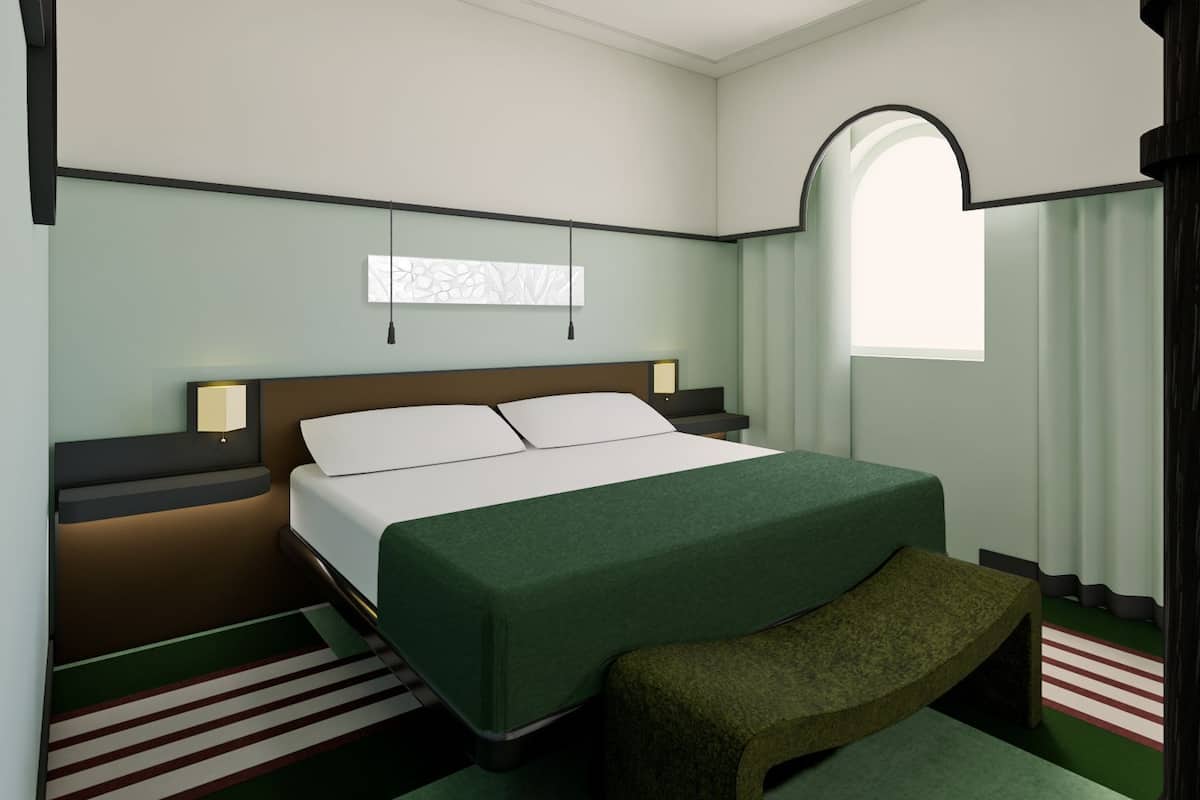Une chambre d’hôtel comprenant un lit, des tables de chevet, un banc, une fenêtre et une œuvre d’art accrochée au mur.