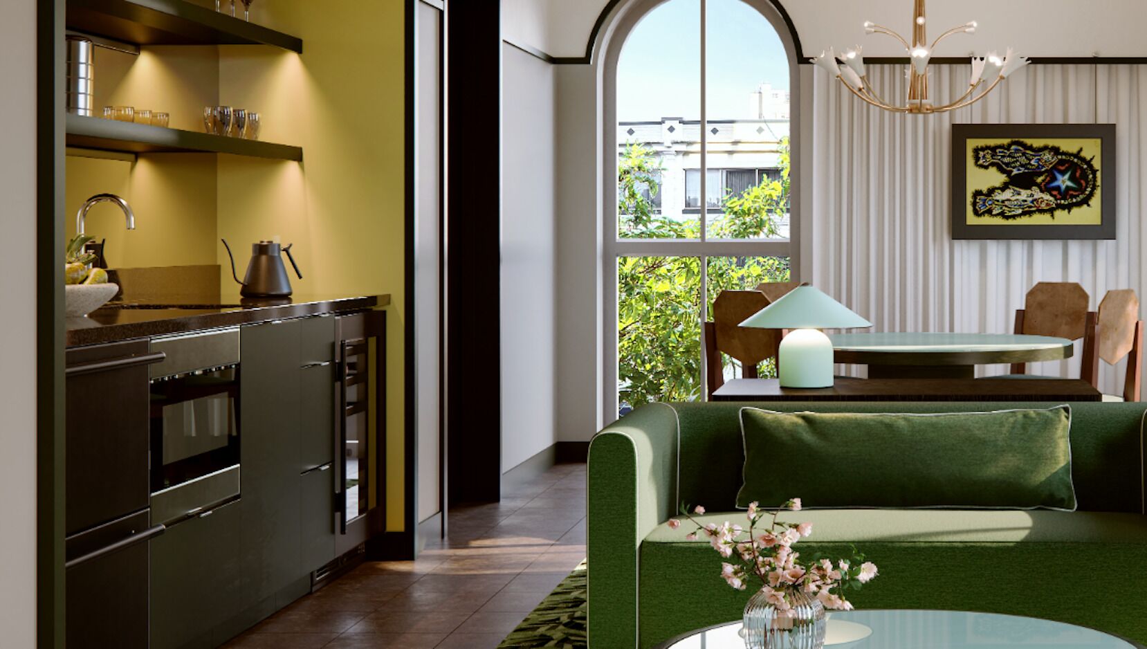 A modern kitchen with stainless steel appliances and a dining area with a green sofa and a table.