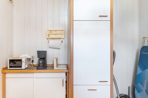 Eine Küchenzeile mit Kaffeemaschine, Toaster und kleinem Kühlschrank.