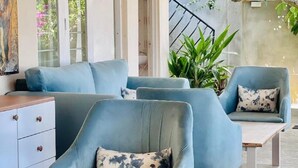 Ein stilvoller Lounge-Bereich mit blauen Sesseln und einem Holztisch.