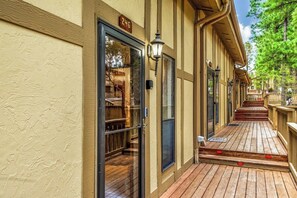A building with a wooden deck, a glass door with a number sign, and a lamp post. - Innsbrook Vacation Condo 246 (Ruidoso)