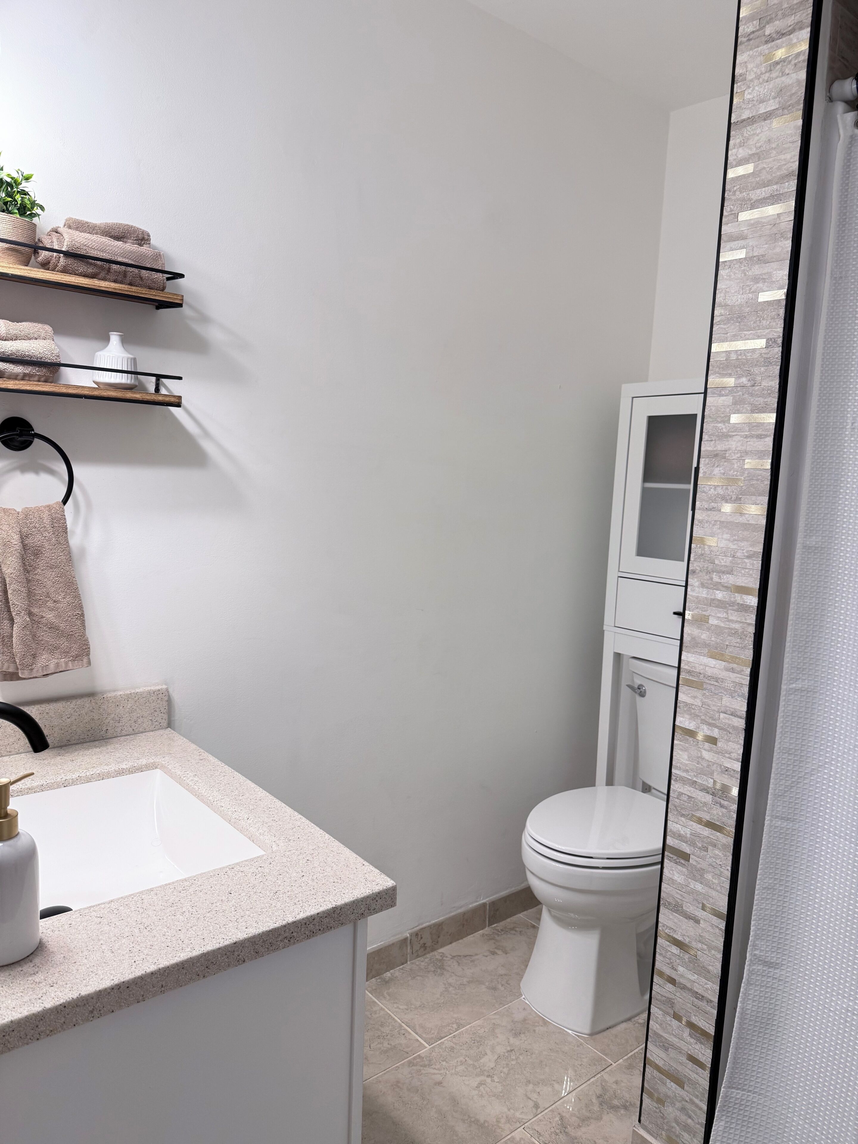 Un baño moderno con un lavabo blanco, un inodoro y una zona de ducha.