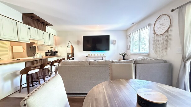 A modern kitchen with a dining area, a flat-screen TV, and a dreamcatcher decoration. - Mountain Creek Condo Waterpark Ski Resort (Vernon Township)