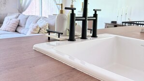 A modern bathroom with a white sink, black faucet, and a wooden countertop. - Mountain Creek Condo Waterpark Ski Resort (Vernon Township)