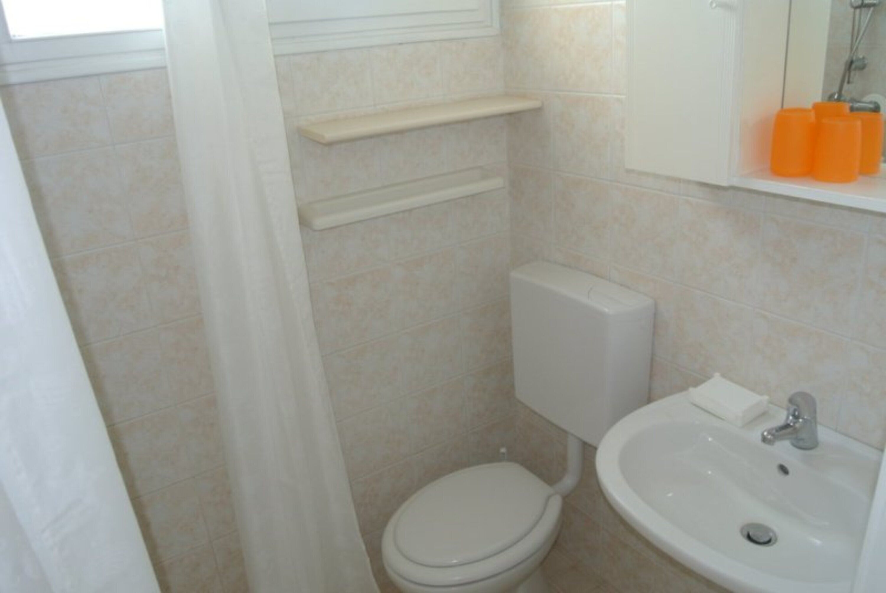 Ein Badezimmer mit Toilette, Waschbecken und Duschbereich.