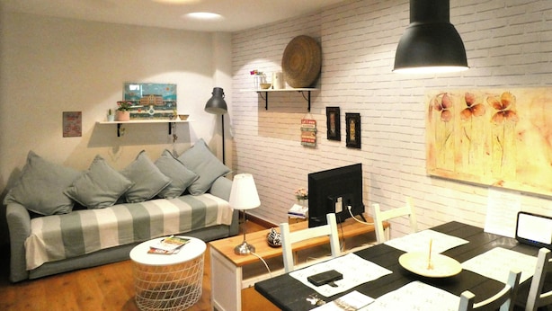 Una sala de estar moderna con un sofá, una mesa de comedor y una televisión.
