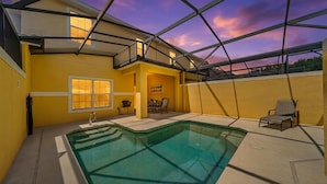 A swimming pool with a glass bottom, a covered patio area, and a view of the sky. - NEW! Minutes to Disney World, Themed, Private Pool, Poolside Bar, Movie Theatre! (Kissimmee)
