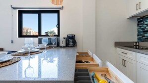 Una cocina con una isla grande, un ventanal con vistas y un microondas empotrado.