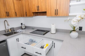 Eine moderne Küche mit Holzausbau, Spülmaschine, Spüle und Herd auf der Arbeitsplatte.