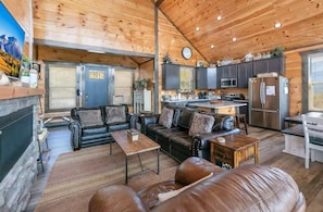 A cozy cabin interior with a living room, kitchen, and a fireplace. - Picadilly Perch (Gatlinburg)
