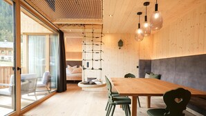 A modern interior with a wooden dining table, chairs, and a hanging light fixture. - Vrbo Property (Prateria)
