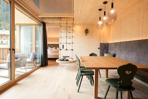 Un interno moderno con un tavolo da pranzo in legno, sedie e un lampadario.