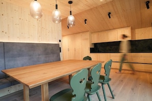 Una cucina moderna con mobili in legno, un tavolo da pranzo in legno e sedie verdi.