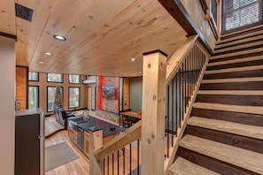 A wooden interior with a kitchen, dining area, and a staircase. - Waterfalls and Wildflowers (Gatlinburg)