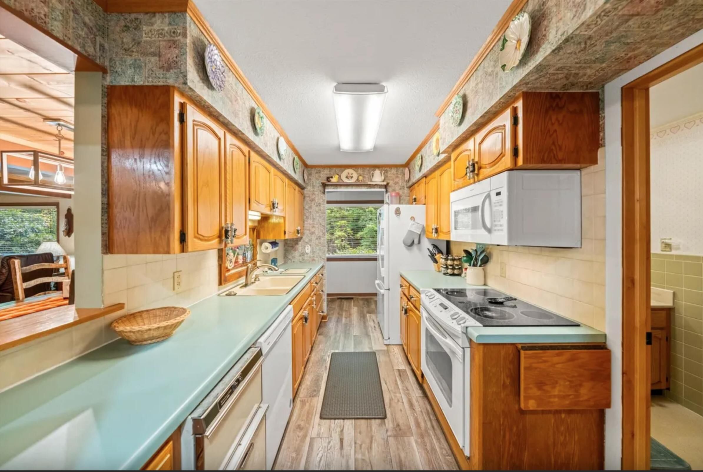 A compact kitchen with wooden cabinets, a built-in stove, and a refrigerator.