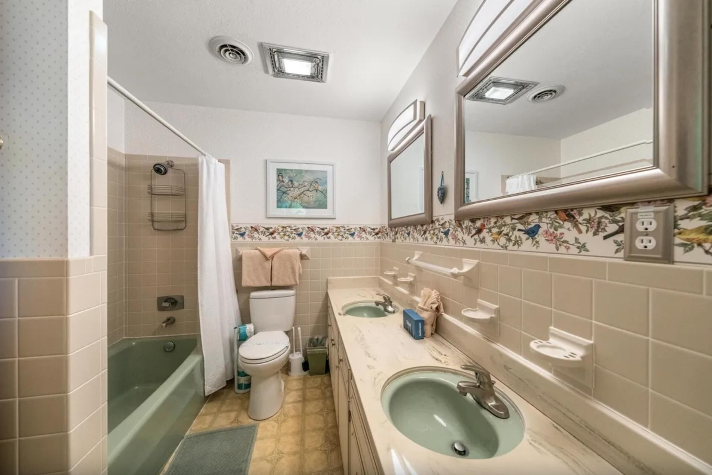 A bathroom with a bathtub, two sinks, a toilet, and a shower.