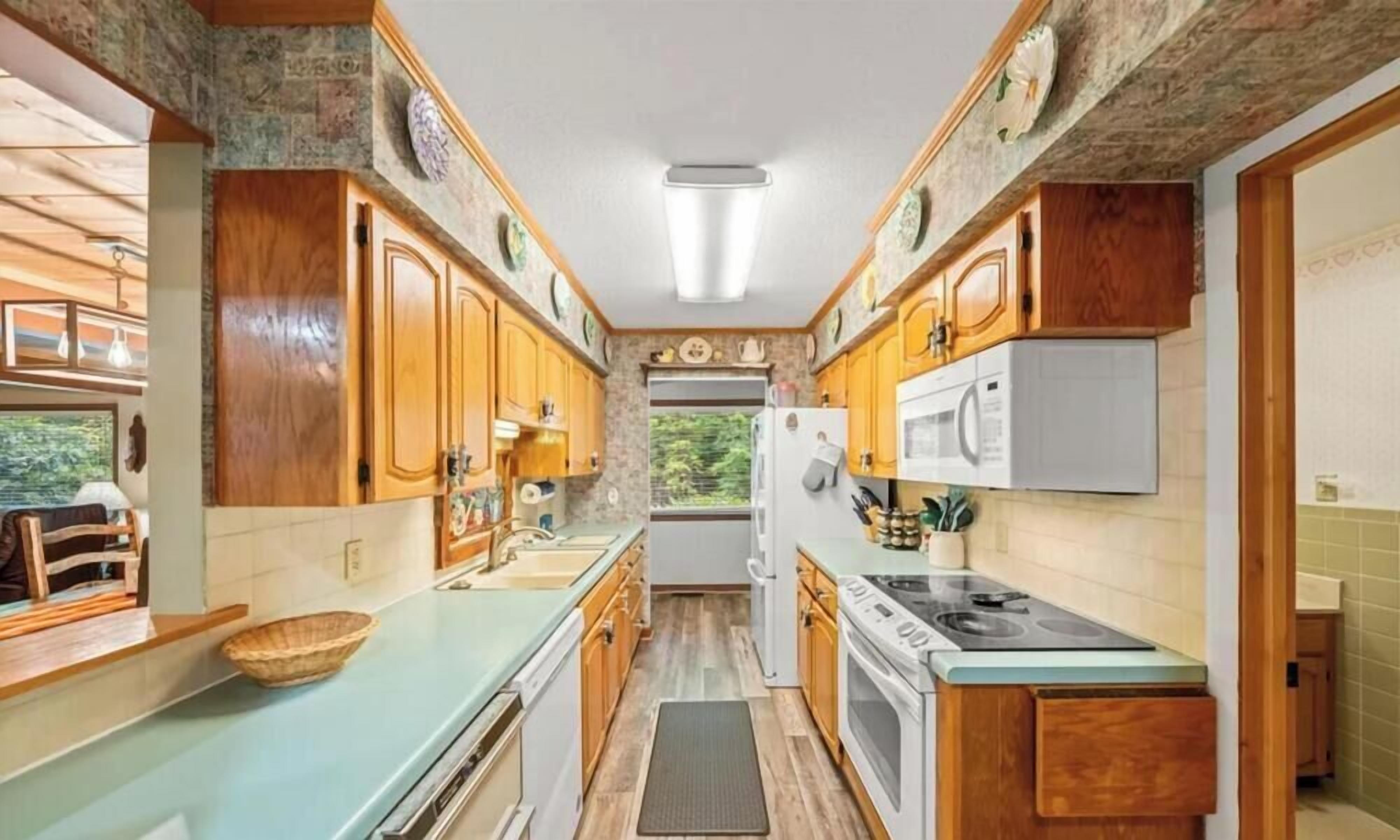 A compact kitchen with wooden cabinets, a built-in stove, and a refrigerator.