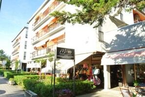 Ein mehrstöckiges Gebäude mit Balkonen, eine Schild für ein Boutique-Hotel und ein Schaufenster mit verschiedenen Artikeln.