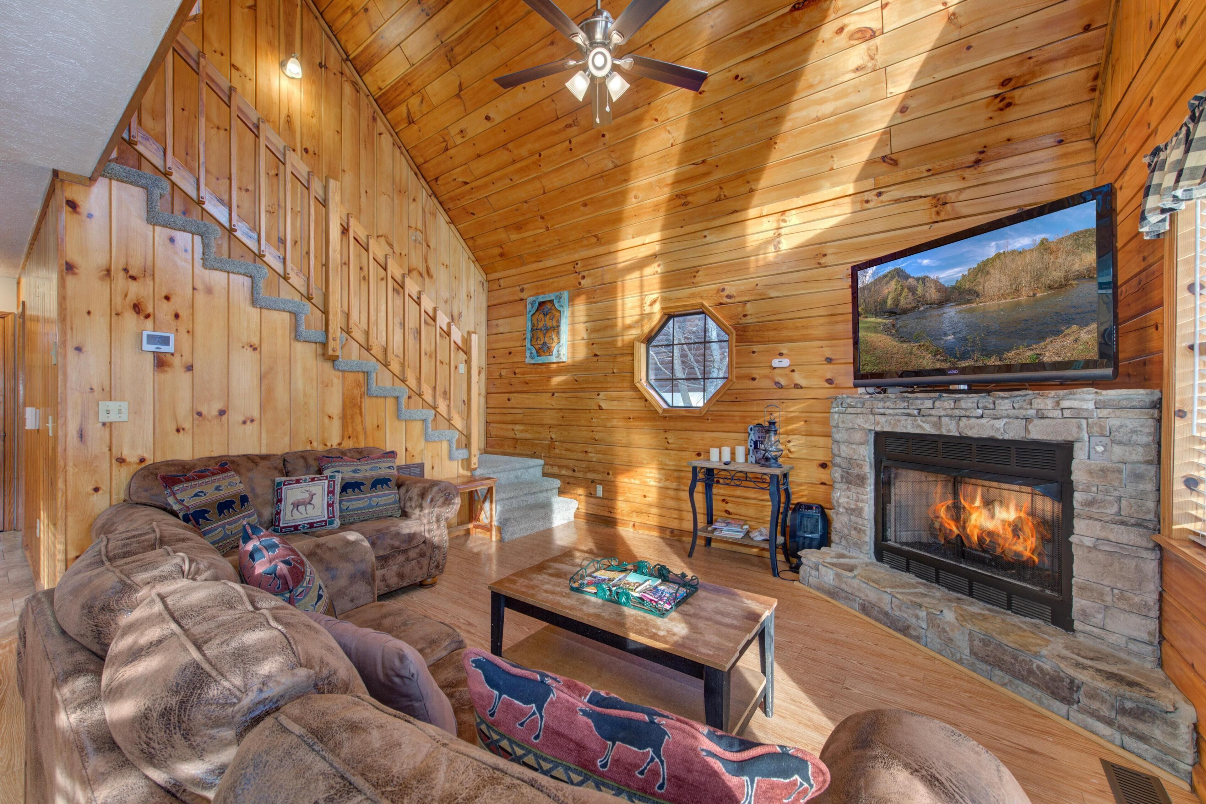 Un interior de madera con chimenea, televisor y escalera.