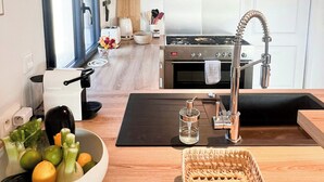 A modern kitchen with a stainless steel range, a microwave, and a built-in oven. - Beachside villa with jacuzzi in Brignogan (Brignogan Plages)