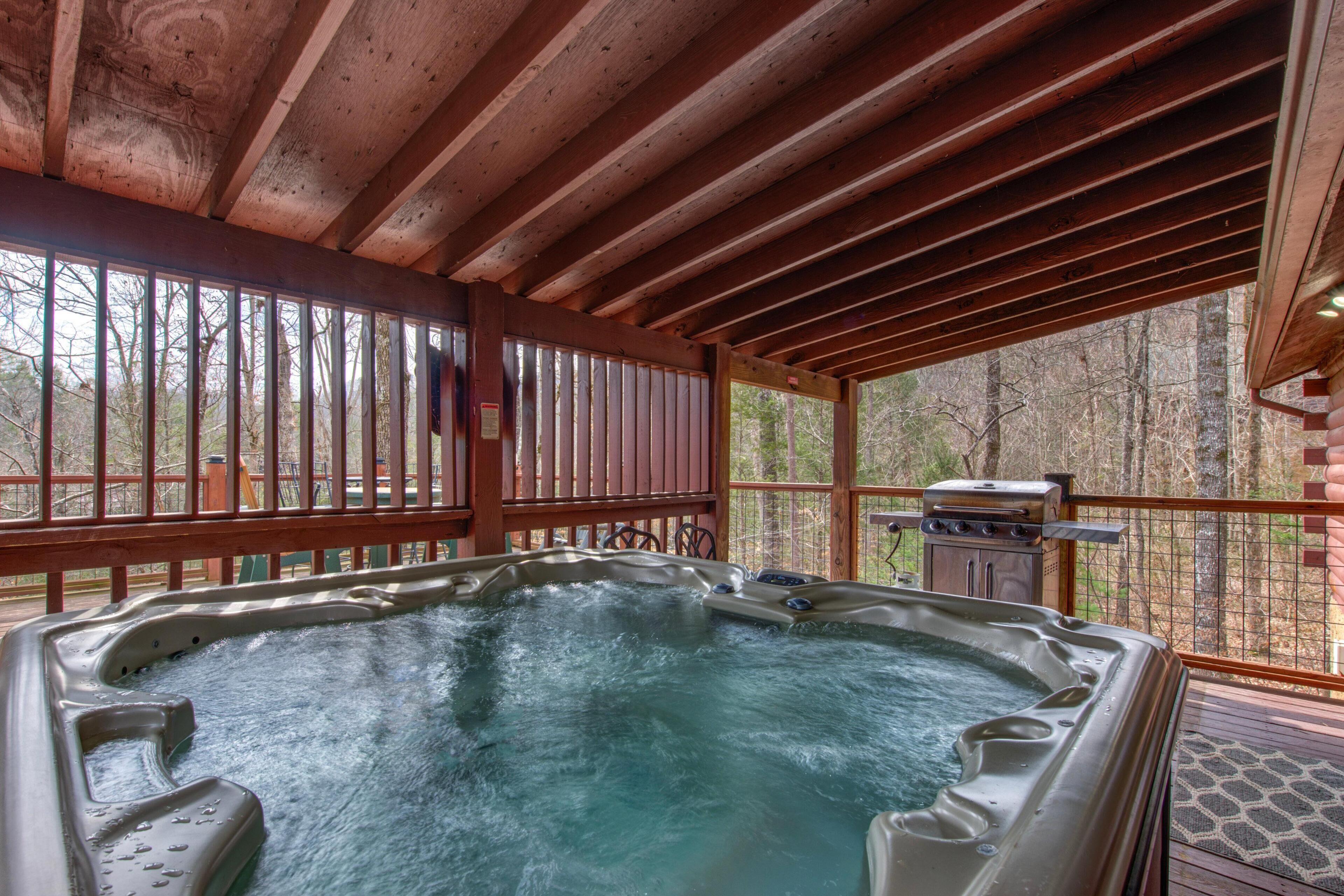 A hot tub in a covered outdoor area with wooden beams and a view of trees.