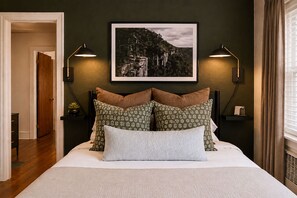 Olive walls, sconces angled for the late readers, and a framed shot of the gorge over the bed, so you wake up knowing exactly where you are and remembering why you came in the first place.