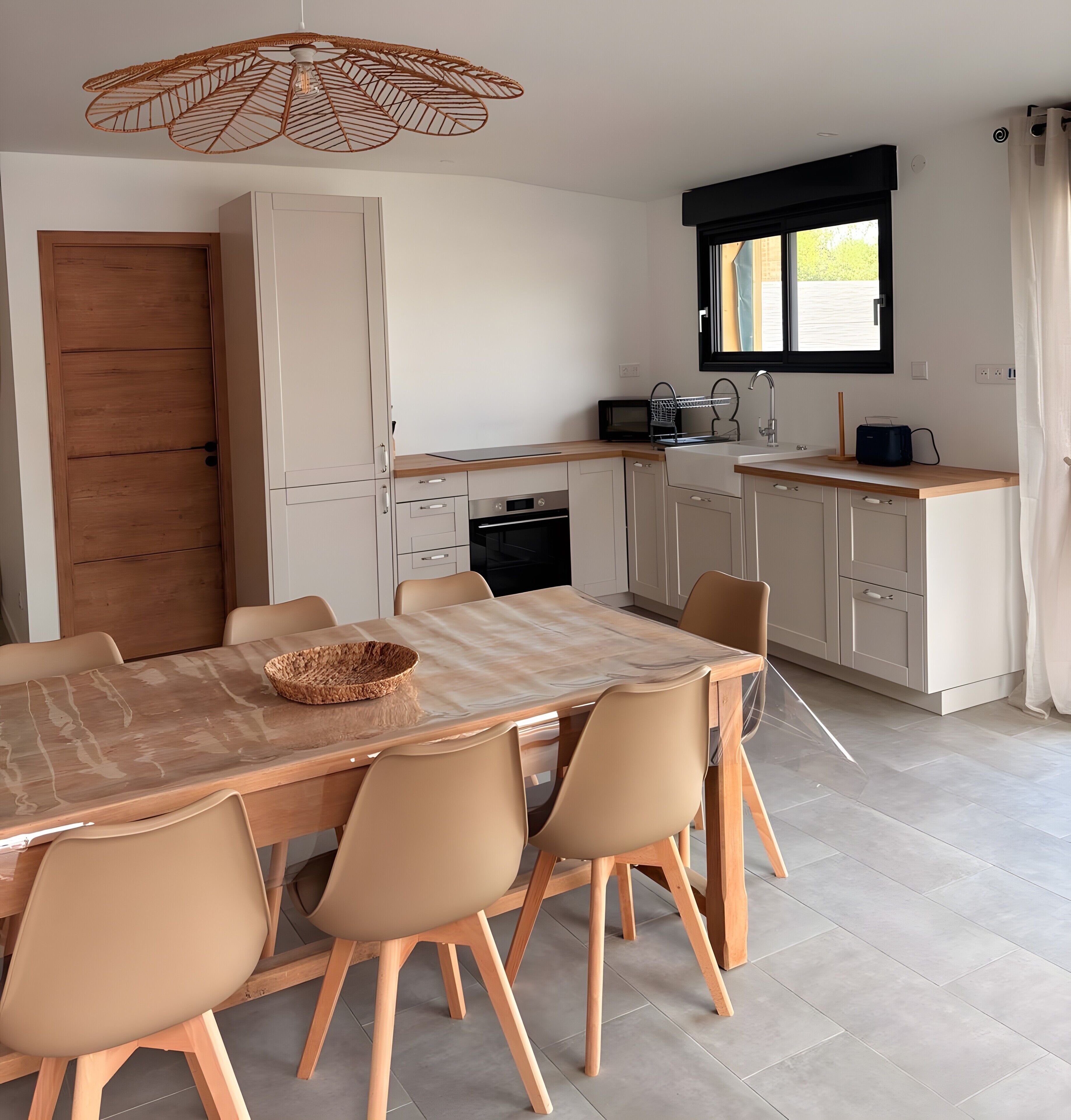 A modern kitchen with a dining table, chairs, a microwave, and a sink.