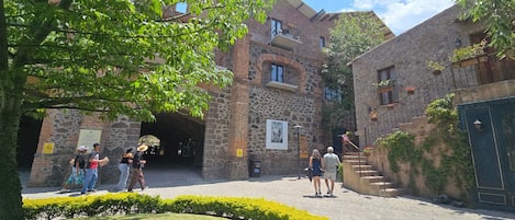 Un patio con edificios de piedra, un sendero pavimentado y una pequeña zona ajardinada.