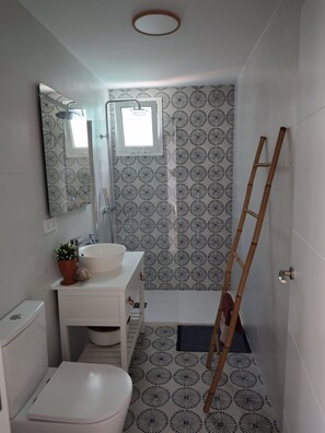 Une salle de bain Ă©quipĂ©e de toilettes, dâun lavabo, dâun miroir, dâune douche et dâune Ă©chelle.