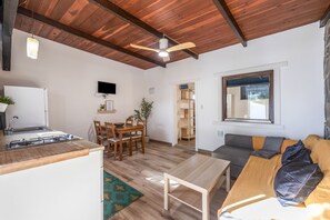 Un espacio habitable compacto con cocina, comedor y zona de estar.