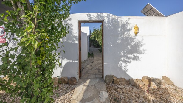 A pathway leading to a building entrance, surrounded by white walls, a small lamp, and a tree. - Casa Marina - Sunwaves El Palmar, 5 min from the beach, private garden & Wi-Fi (El Palmar de Vejer)