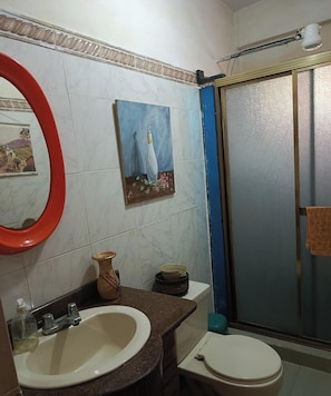 A bathroom with a sink, toilet, and a shower enclosure.