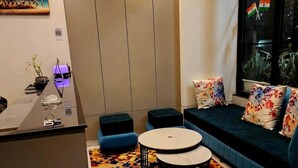 A modern living room with a sofa, a coffee table, and a patterned rug. - CHERRY TREE (Greater Noida)