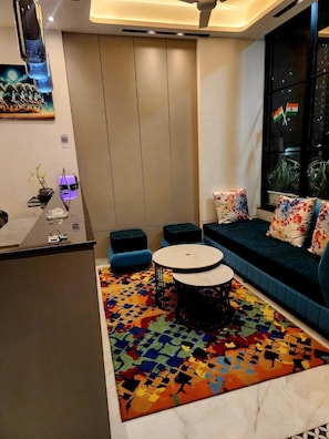A modern living room with a sofa, a coffee table, and a patterned rug. - CHERRY TREE (Greater Noida)