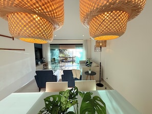 Una sala de estar moderna con comedor, ventanas amplias y vistas al exterior.