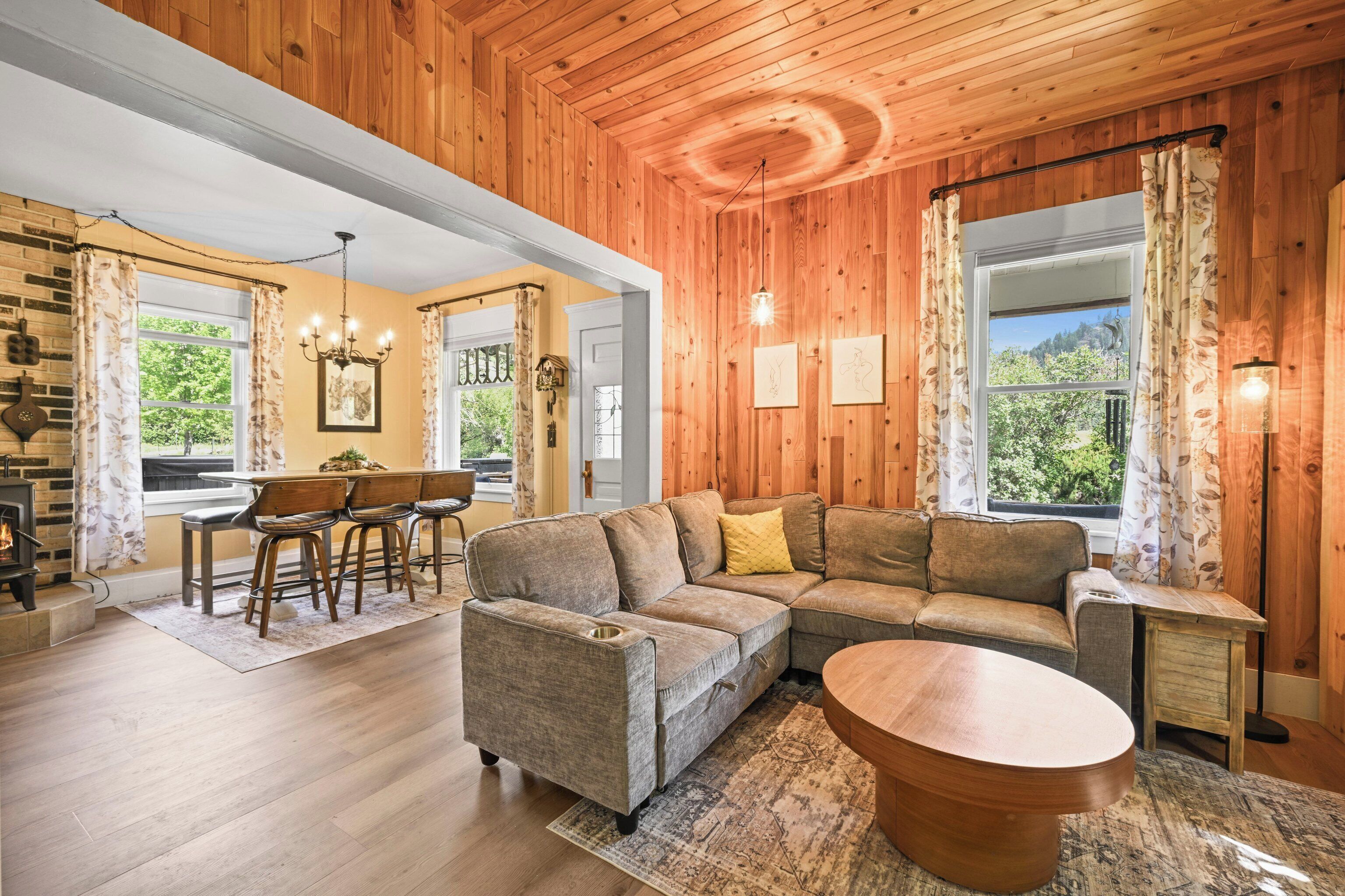 A cozy living room with a sectional sofa, a wooden coffee table, and a dining area with chairs and a table.