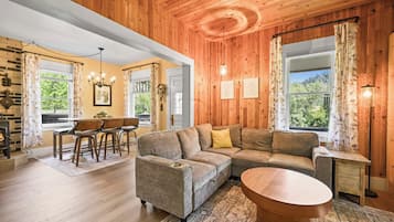 A cozy living room with a sectional sofa, a wooden coffee table, and a dining area with chairs and a table.