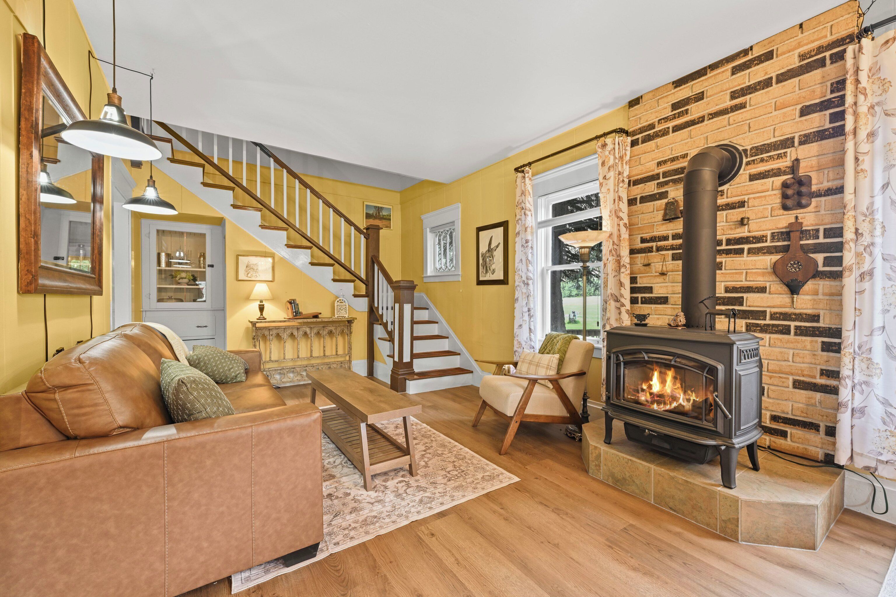 A living room with a fireplace, a staircase, and a sofa.