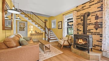 A living room with a fireplace, a staircase, and a sofa.