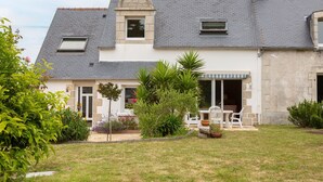 A two-story house with a stone facade, a tiled roof, and a small porch with outdoor furniture. - Bed and Breakfast 'Une Chambre À Lestriguiou' with Private Terrace, Private Garden and Wi-Fi (Plomeur)