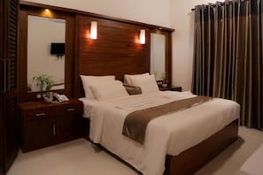 A bedroom with a wooden headboard, a bedside table with a phone, and a large mirror. - Idyllic Vista - Kandy (Kandy)