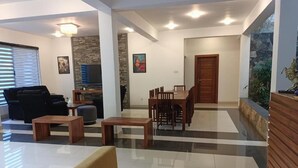 Un'ampia zona giorno con divano, tavolino e tavolo da pranzo con sedie.