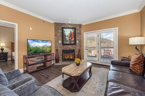 Ein Wohnzimmer mit Kamin, Fernseher, Sofa und Couchtisch.