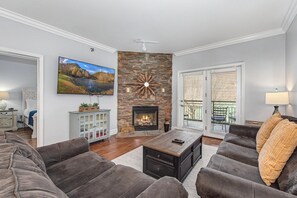 Ein Wohnzimmer mit Kamin, Fernseher und einer Couch.