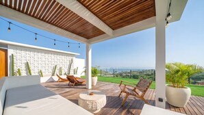 A covered outdoor seating area with a view of the landscape. - Karma 3 Villa (Badung)
